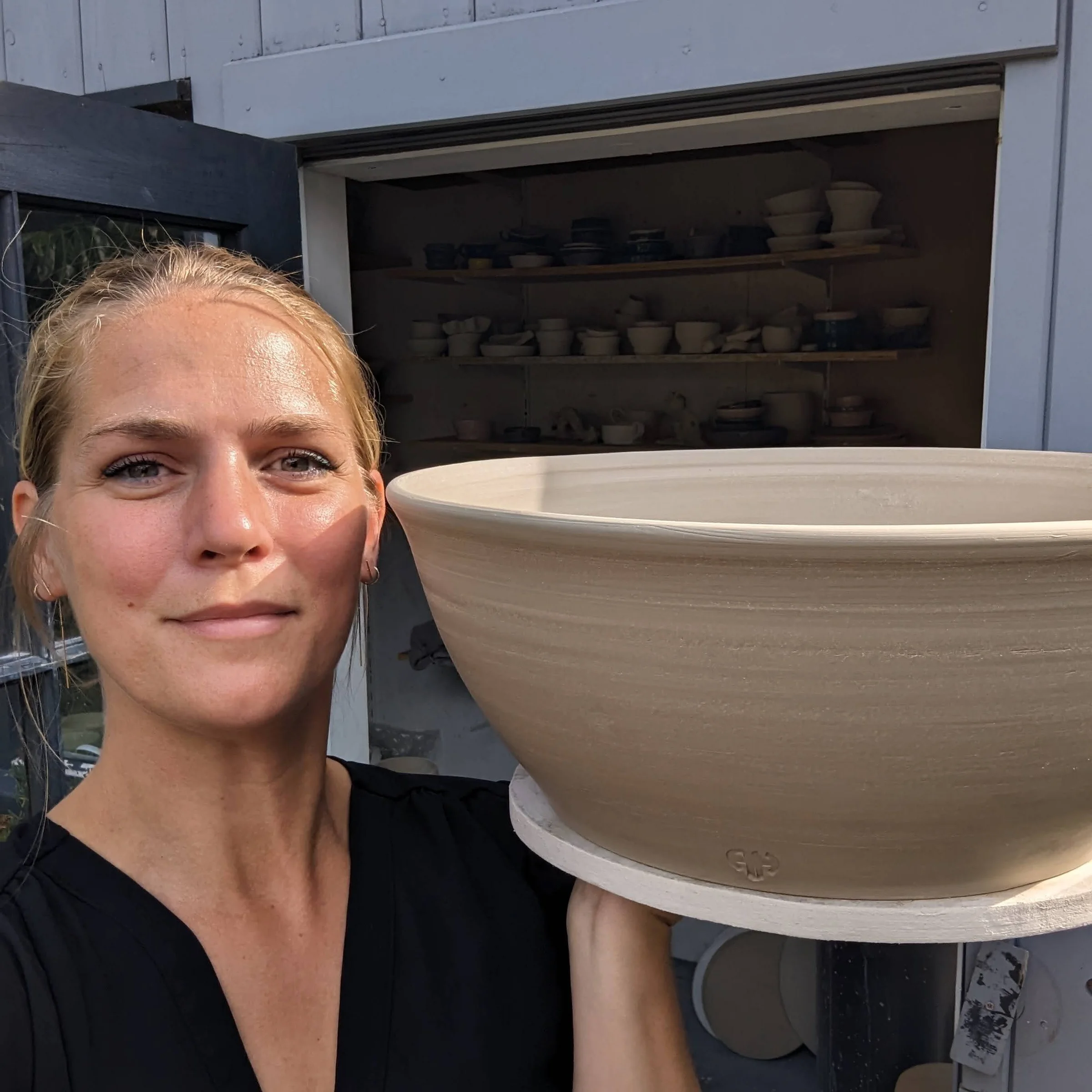 Amanda holding a large freshly thrown ceramic bowl