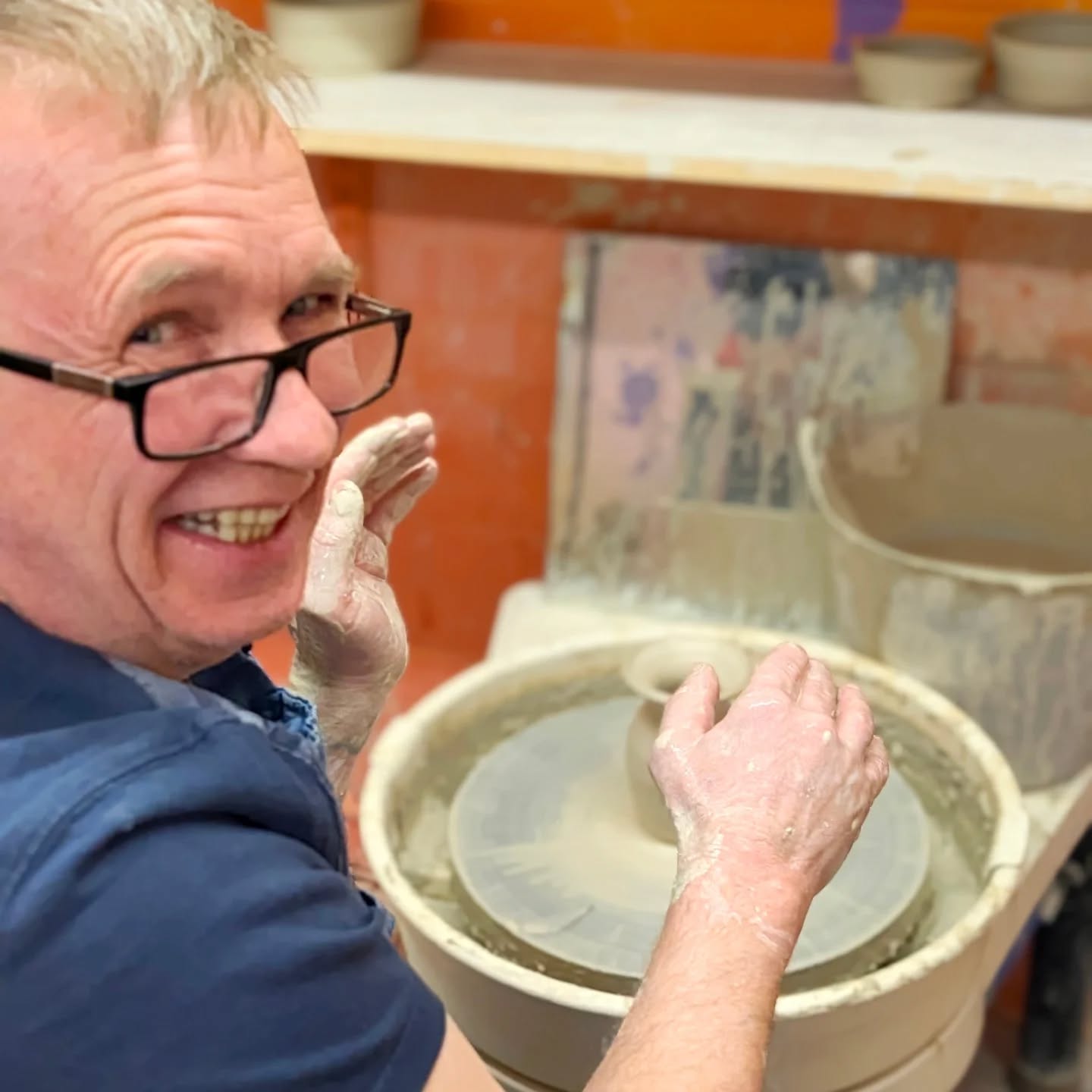 Student laughing at the pottery wheel