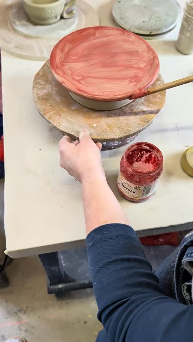 Glazing a bowl in rich red at the studio