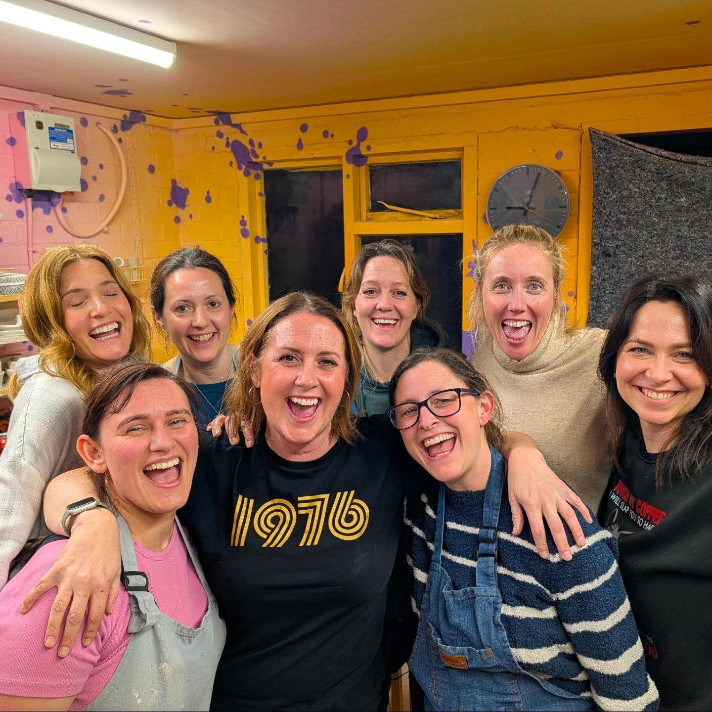 Group of friends laughing together at a pottery party