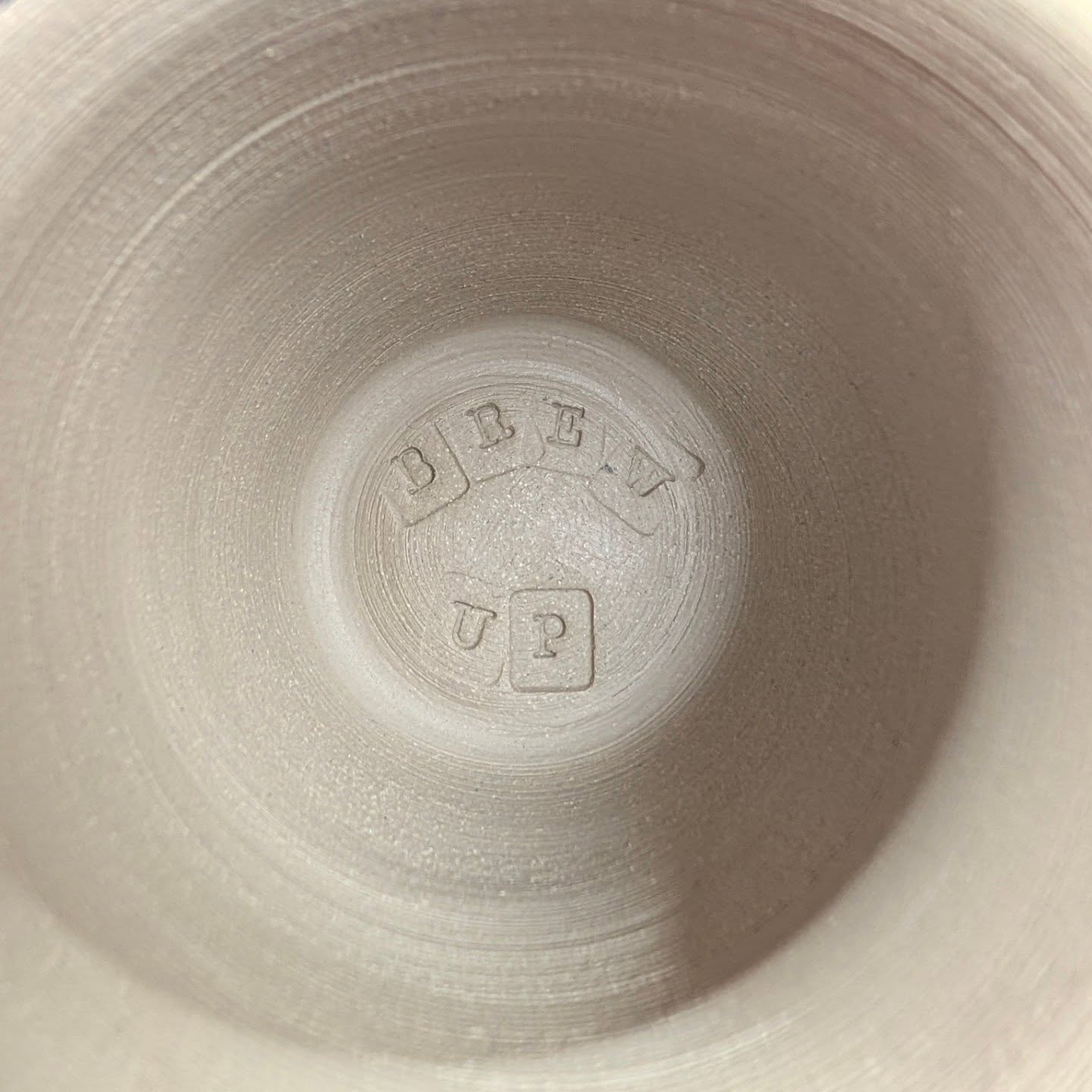 Inside of a handmade Brew Up pottery mug